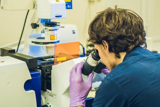 Scientist work on a confocal scanning microscope in a laboratory for biological samples investigation.