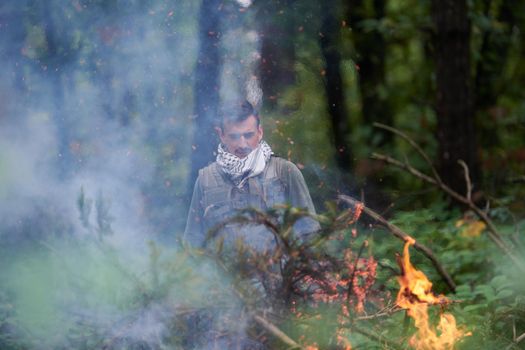 terrorist have a break and smoke cigarette in forest during battle