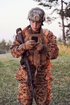 soldier using smart phone to contact family or girlfriend communication and nostalgia concept