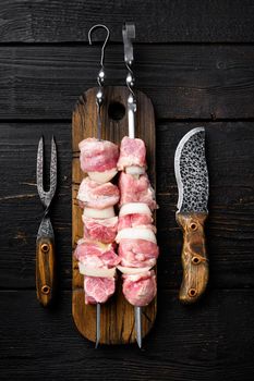 Raw kebab set, top view flat lay, on black wooden table background