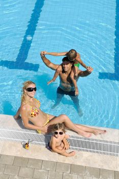 happy young family have fun on swimming pool  at summer vacation