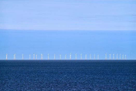 Tall white wind turbines in the distance