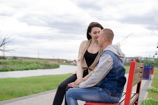 beautiful young couple sitting on a bench in the park.