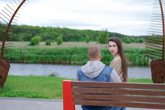 beautiful young couple sitting on a bench in the park.