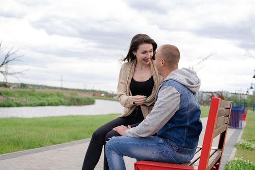 beautiful young couple sitting on a bench in the park.