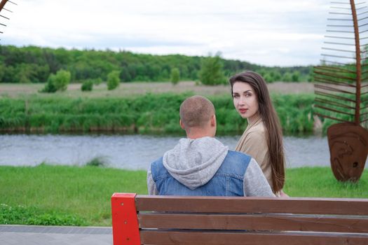 beautiful young couple sitting on a bench in the park.