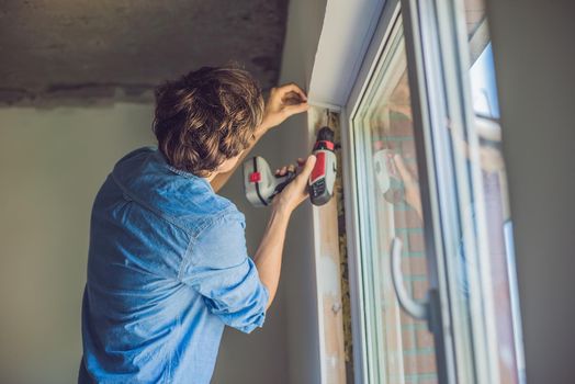 Man in a blue shirt does window installation.