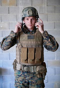 soldier preparing tactical protective and communication gear for action battle
