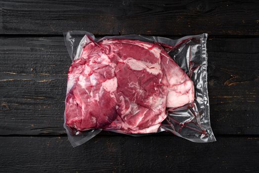 Vacuum packed meat set, on black wooden table background, top view flat lay, with copy space for text
