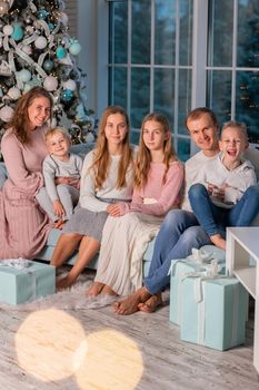 Big Happy family with many kids having fun on the sofa near the Christmas tree. Christmas family eve, christmas mood concept