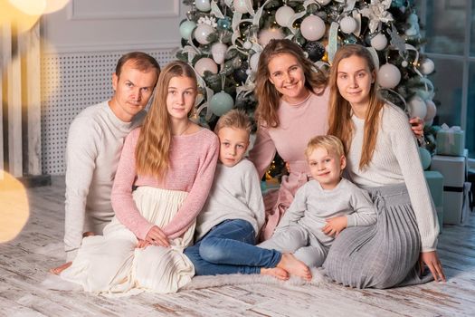 Big Happy family with many kids having fun and opening presents under the Christmas tree. Christmas family eve, christmas mood concept