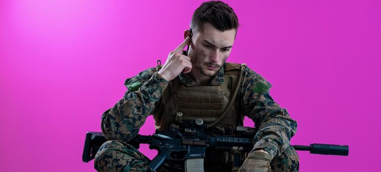 soldier preparing tactical and communication gear for action battle pink background