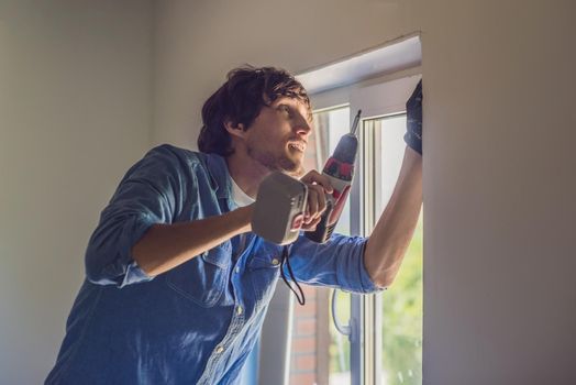 Man in a blue shirt does window installation.