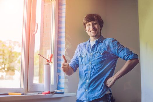 Man in a blue shirt does window installation.