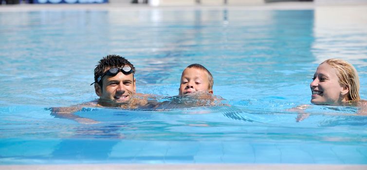 happy young family have fun on swimming pool  at summer vacation