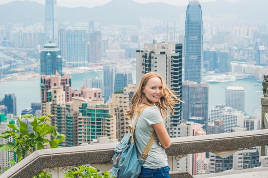 Young woman traveler at the peak of Victoria against the backdrop of Hong Kong.