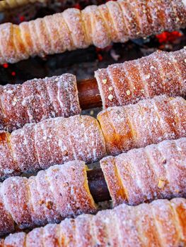 Baking popular trdlo at the street stalls. National street food of the Czech Republic. Blur.