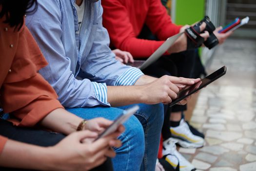 a group of students sit in the school hallway and use notebooks, tablets and cameras to create projects for the school