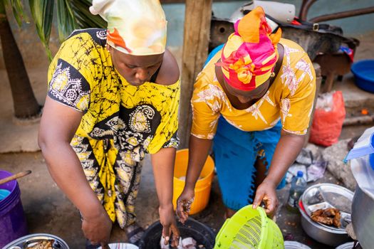 African woman cooking traditional food at street