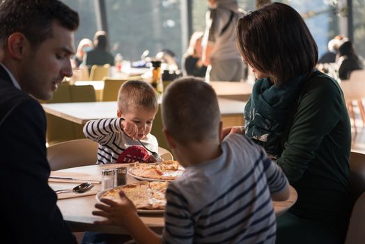 Young parents enjoying lunch time with their children at a luxury restaurant