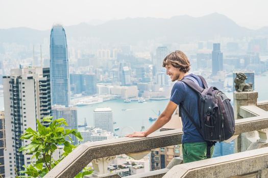 Young man traveler at the peak of Victoria against the backdrop of Hong Kong.