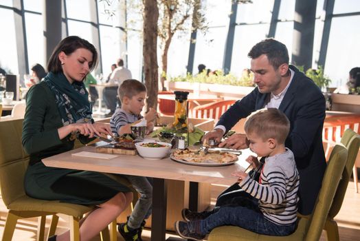 Young parents enjoying lunch time with their children at a luxury restaurant