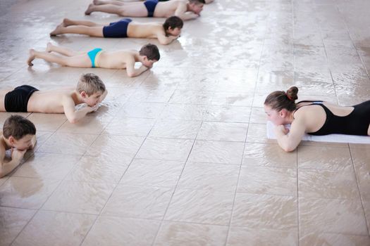 happy children kids group  at swimming pool class  learning to swim