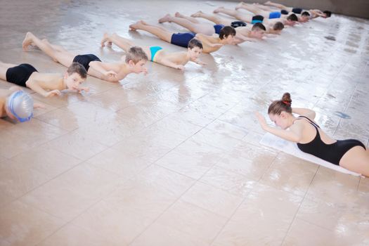 happy children kids group  at swimming pool class  learning to swim