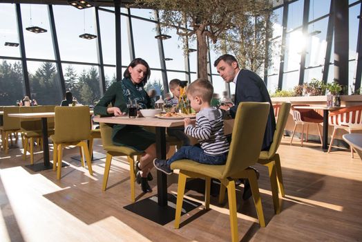 Young parents enjoying lunch time with their children at a luxury restaurant