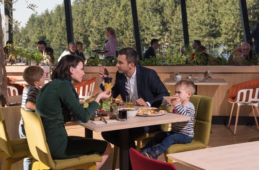 Young parents enjoying lunch time with their children at a luxury restaurant