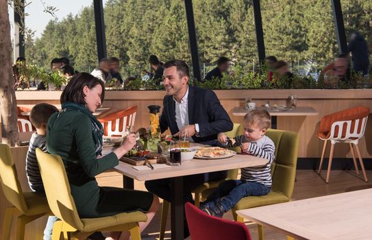 Young parents enjoying lunch time with their children at a luxury restaurant