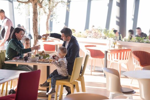 Young parents enjoying lunch time with their children at a luxury restaurant