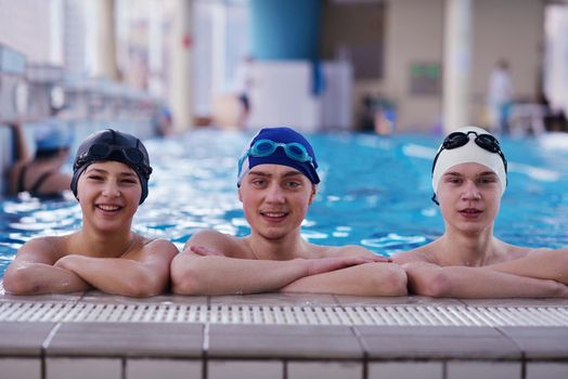 happy teen  group  at swimming pool class  learning to swim and have fun