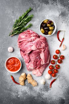 Fresh and raw meat Lamb or mutton set, with ingredients and herbs, on gray stone table background, top view flat lay