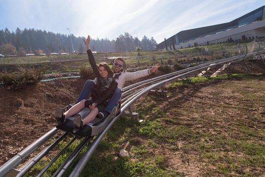 Excited young couple enjoys driving on alpine coaster