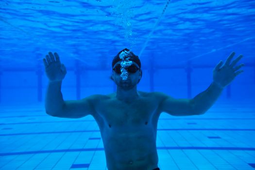 undervater shoot of swimming pool with good looking young swimmer 