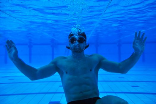 undervater shoot of swimming pool with good looking young swimmer 