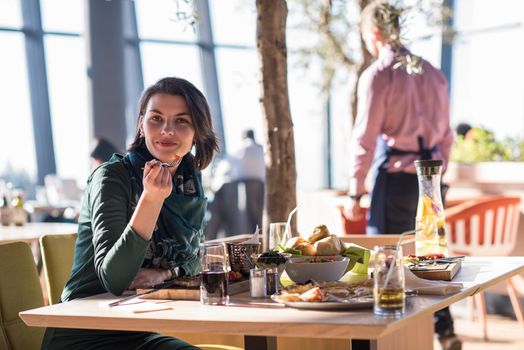 young woman looking happy while having lunch at luxury restaurant