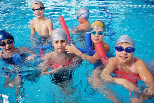 happy children kids group  at swimming pool class  learning to swim