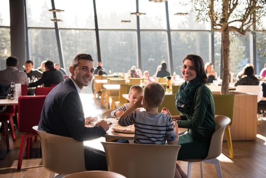 Young parents enjoying lunch time with their children at a luxury restaurant