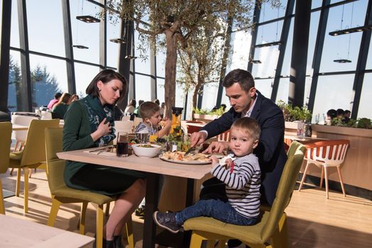 Young parents enjoying lunch time with their children at a luxury restaurant