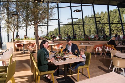 Young parents enjoying lunch time with their children at a luxury restaurant