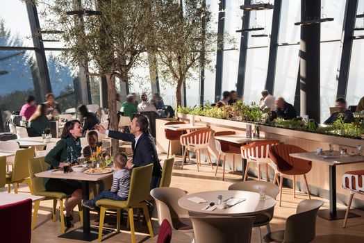 Young parents enjoying lunch time with their children at a luxury restaurant