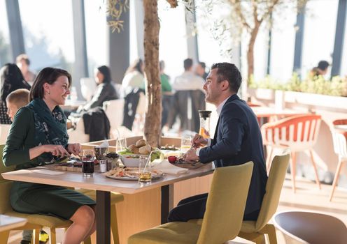 Young parents enjoying lunch time with their children at a luxury restaurant