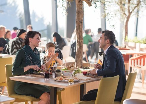 Young parents enjoying lunch time with their children at a luxury restaurant