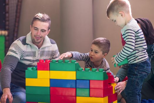 happy family enjoying free time young parents and kids having fun while playing together at childrens playroom