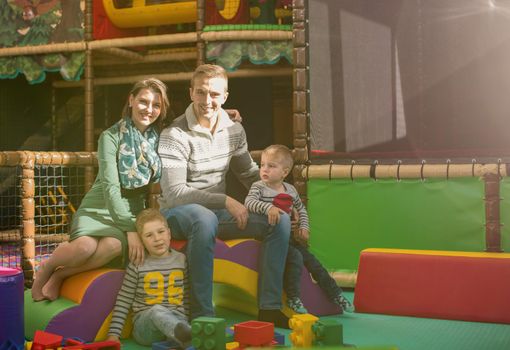 happy family enjoying free time young parents and kids having fun while playing together at childrens playroom