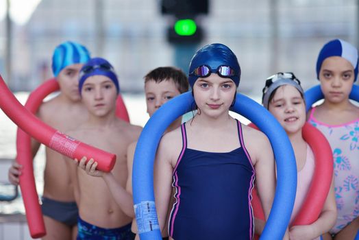 happy children kids group  at swimming pool class  learning to swim