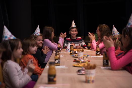 The young boy joyfully celebrating his birthday with a group of his friends