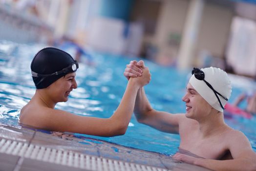 happy teen  group  at swimming pool class  learning to swim and have fun